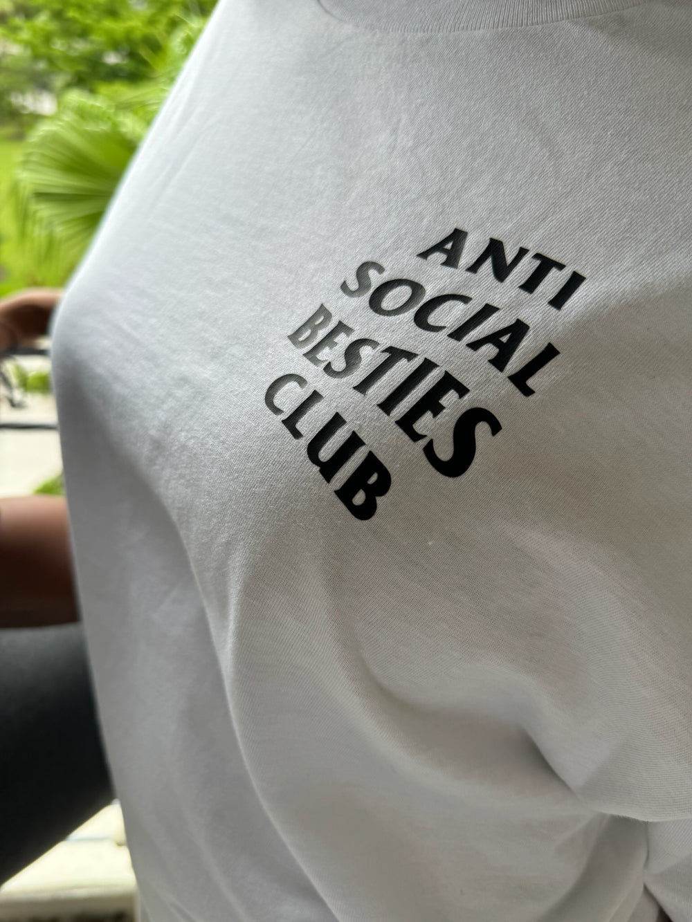 Close-up of 'ANTISOCIAL BESTIES CLUB' text on the right chest of the Dass My Best Friend white t-shirt. Black lettering printed on the front for a bold, minimalist design.