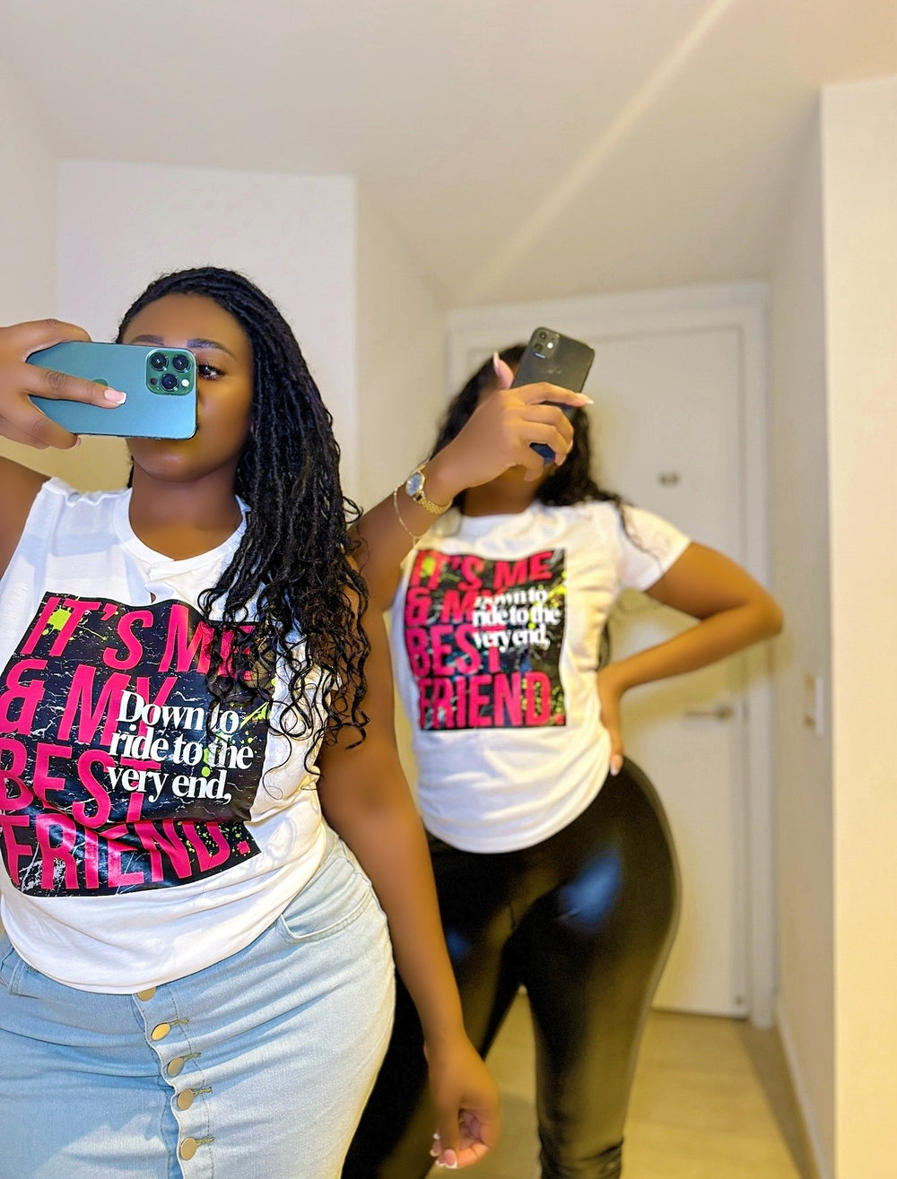 Two women wearing the "Down to Ride" T-shirt by Dass My Best Friend, both taking selfies. One woman is styled in a jeans skirt, highlighting the playful and bold "Down to Ride" design on the feminine-fitted tee, perfect for celebrating adventurous best friends.