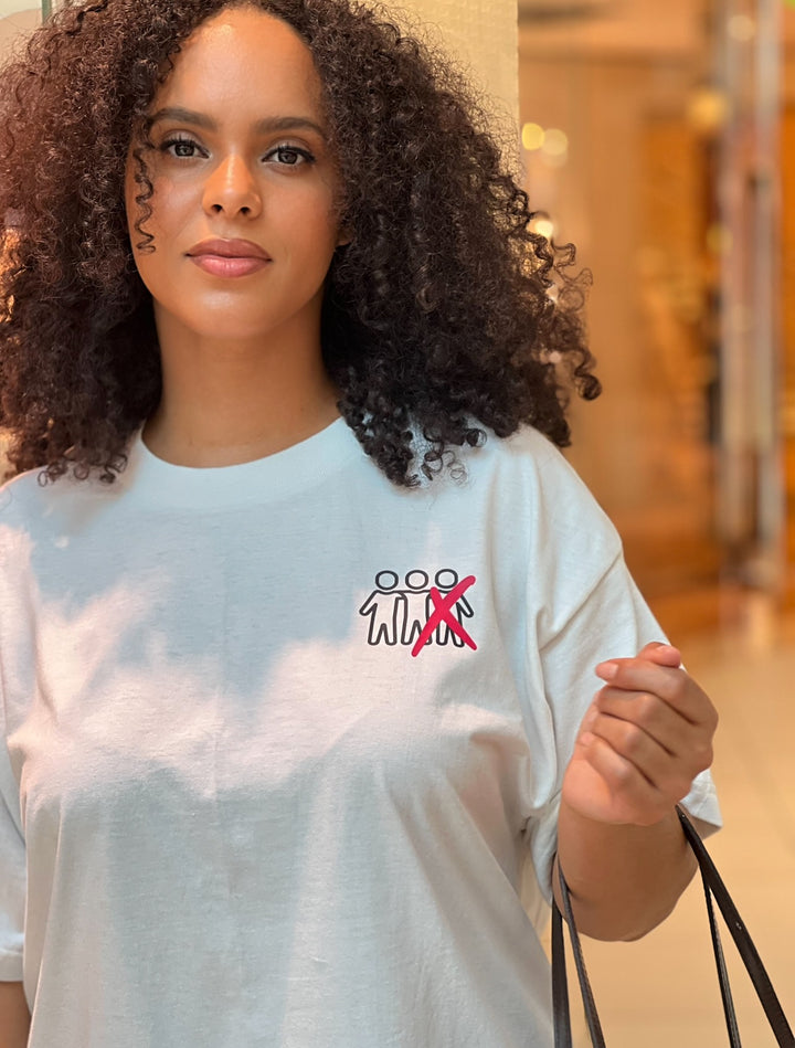 Woman walking in the mall holding a Louis Vuitton handbag, wearing the white "Thou Shall Not" Tee by Dass My Best Friend, frontal view. The bold "Thou Shall Not" graphic is prominently displayed on the front, showcasing the oversized fit and playful message.